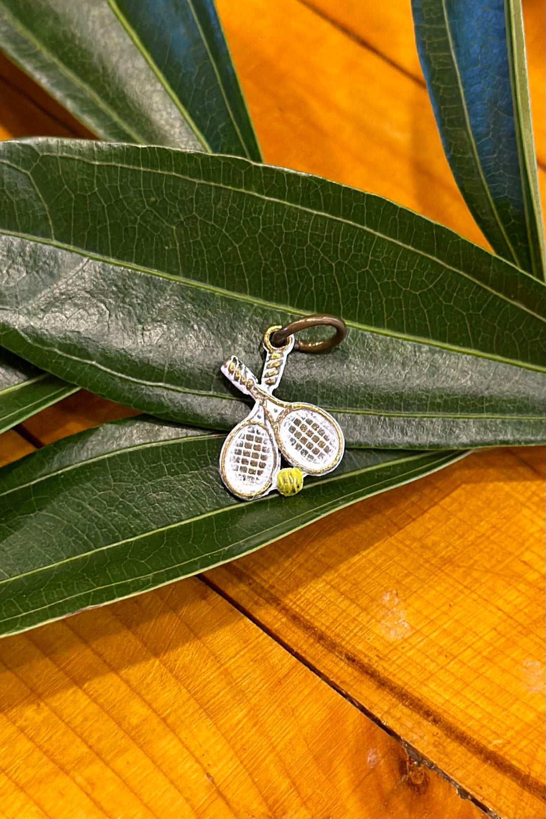 Gleeful Peacock Charm: Tennis Racquets